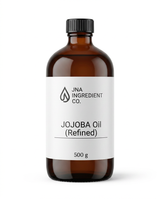 An amber glass bottle of JNA Ingredient Co. Jojoba Oil (Refined) with a white label and a black cap, set against a plain white background.